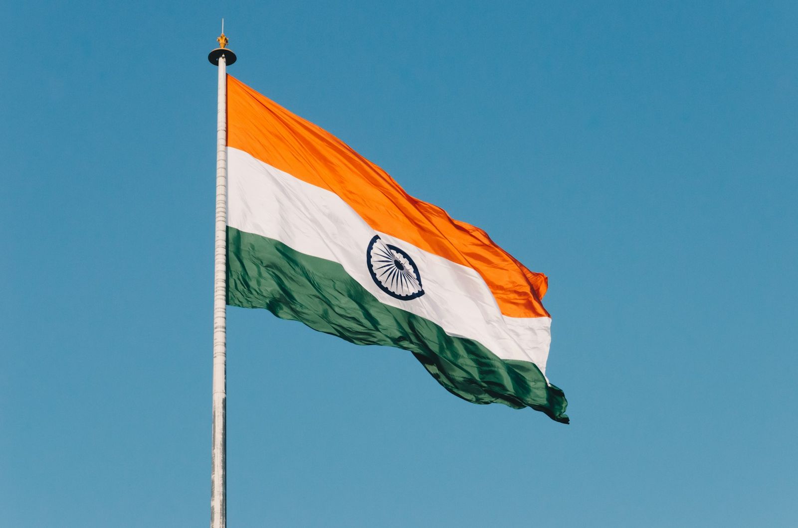 Indian national flag waving against a clear blue sky